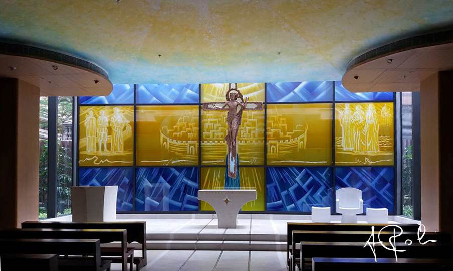 The apse area of the Chapel with the stained glass window, the bronze Crucifix and the liturgical furnishings